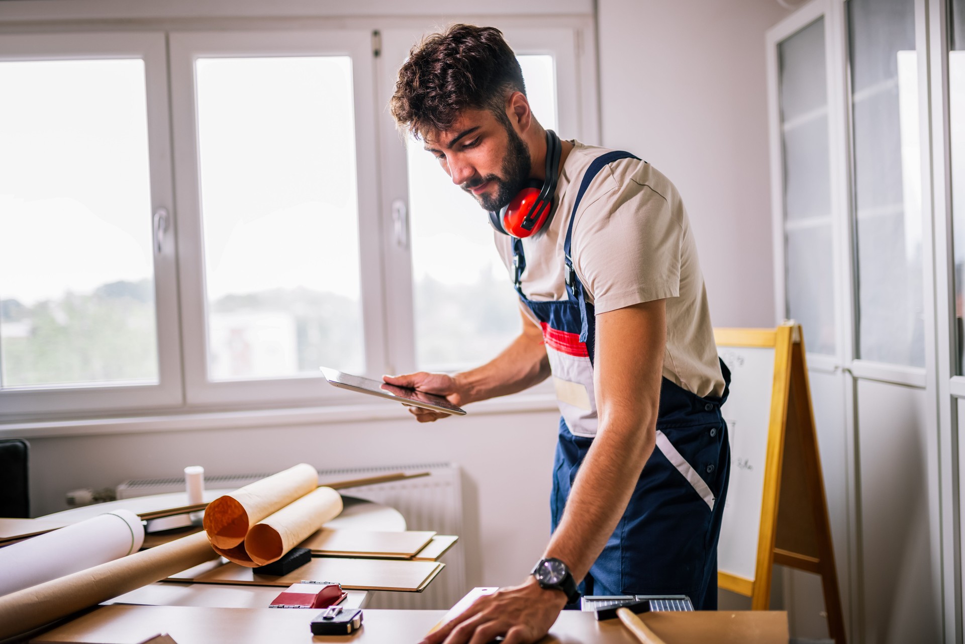 Repairman Using Tablet While Installing Laminate Flooring